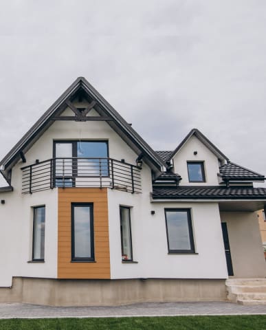 Modern two-story house with white exterior and black roof.